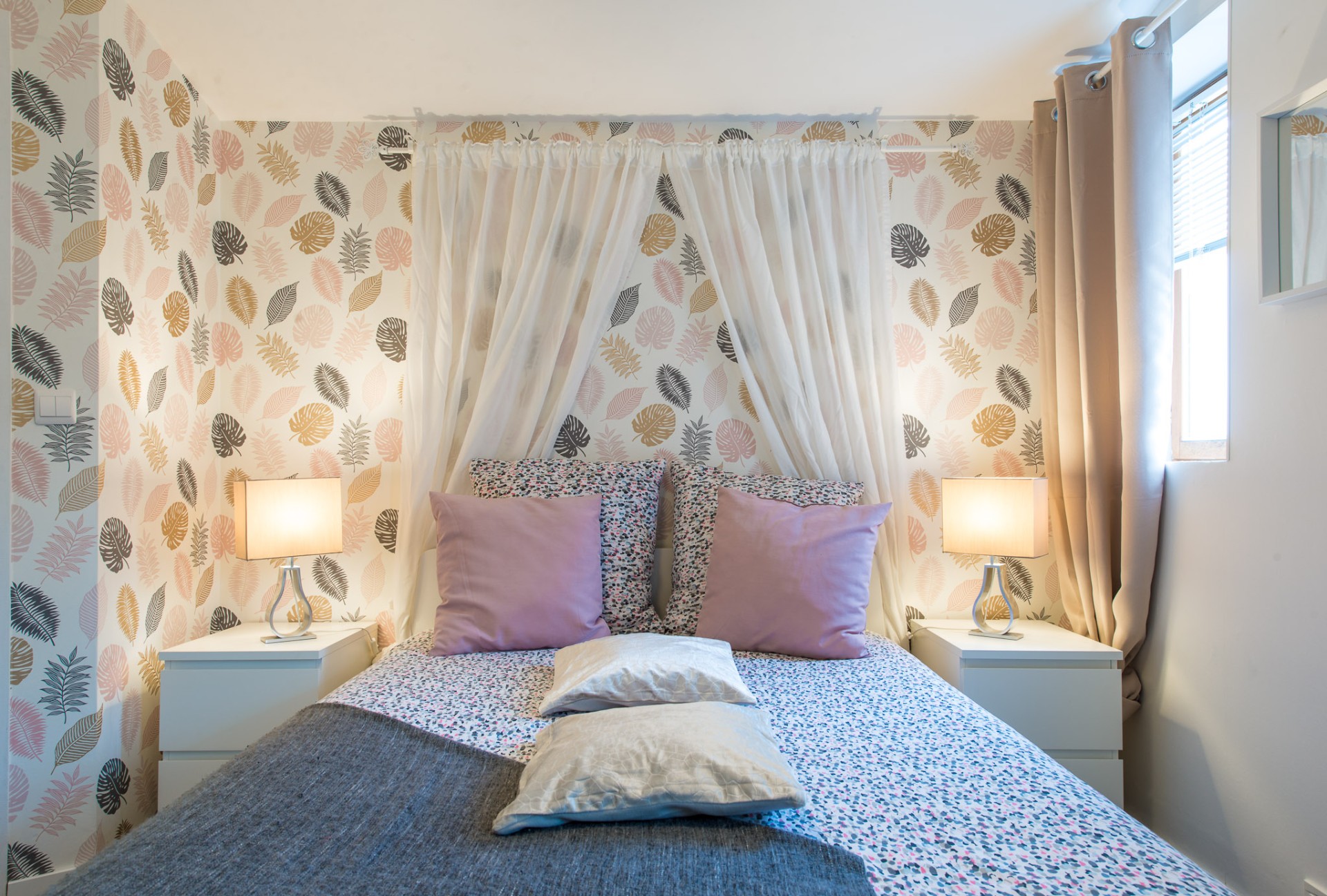Chambre cosy avec papier peint feuillage et éclairage doux